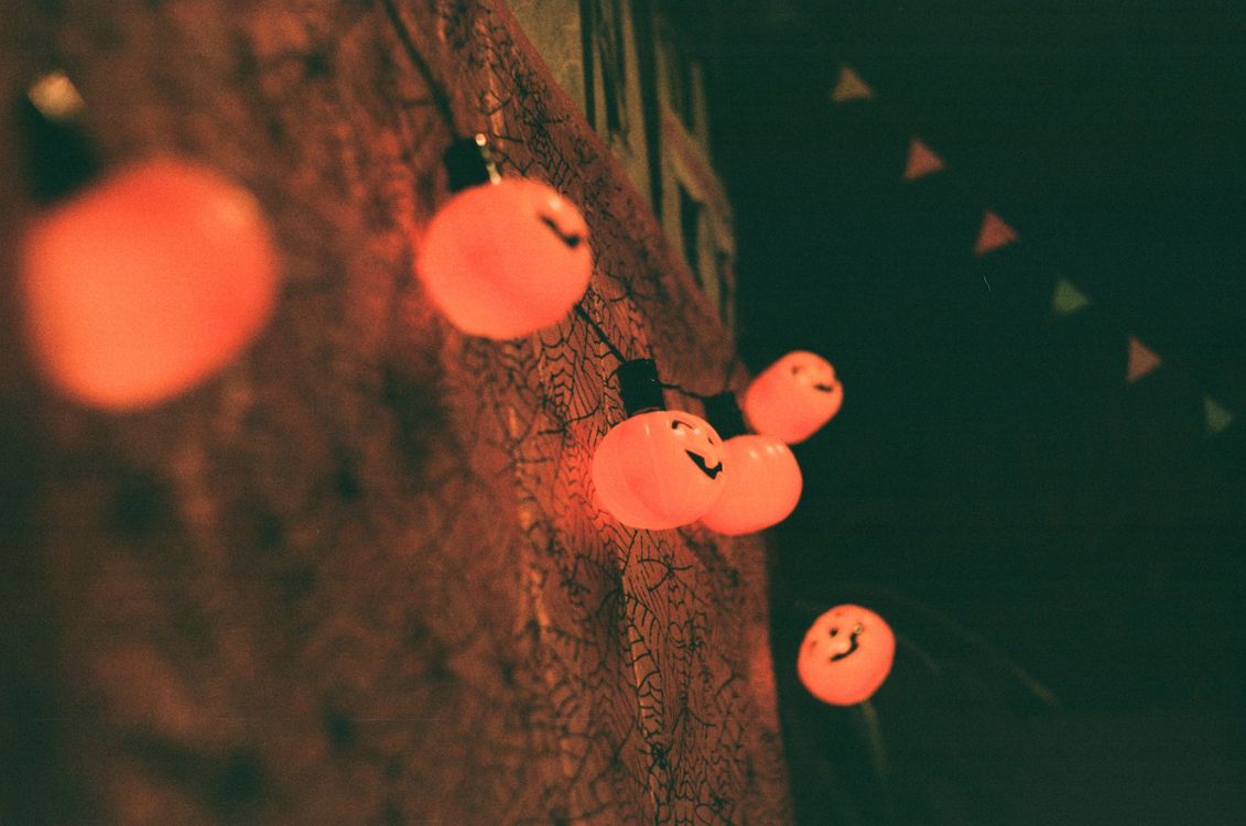Glowing orange pumpkin string lights against a dark Halloween backdrop